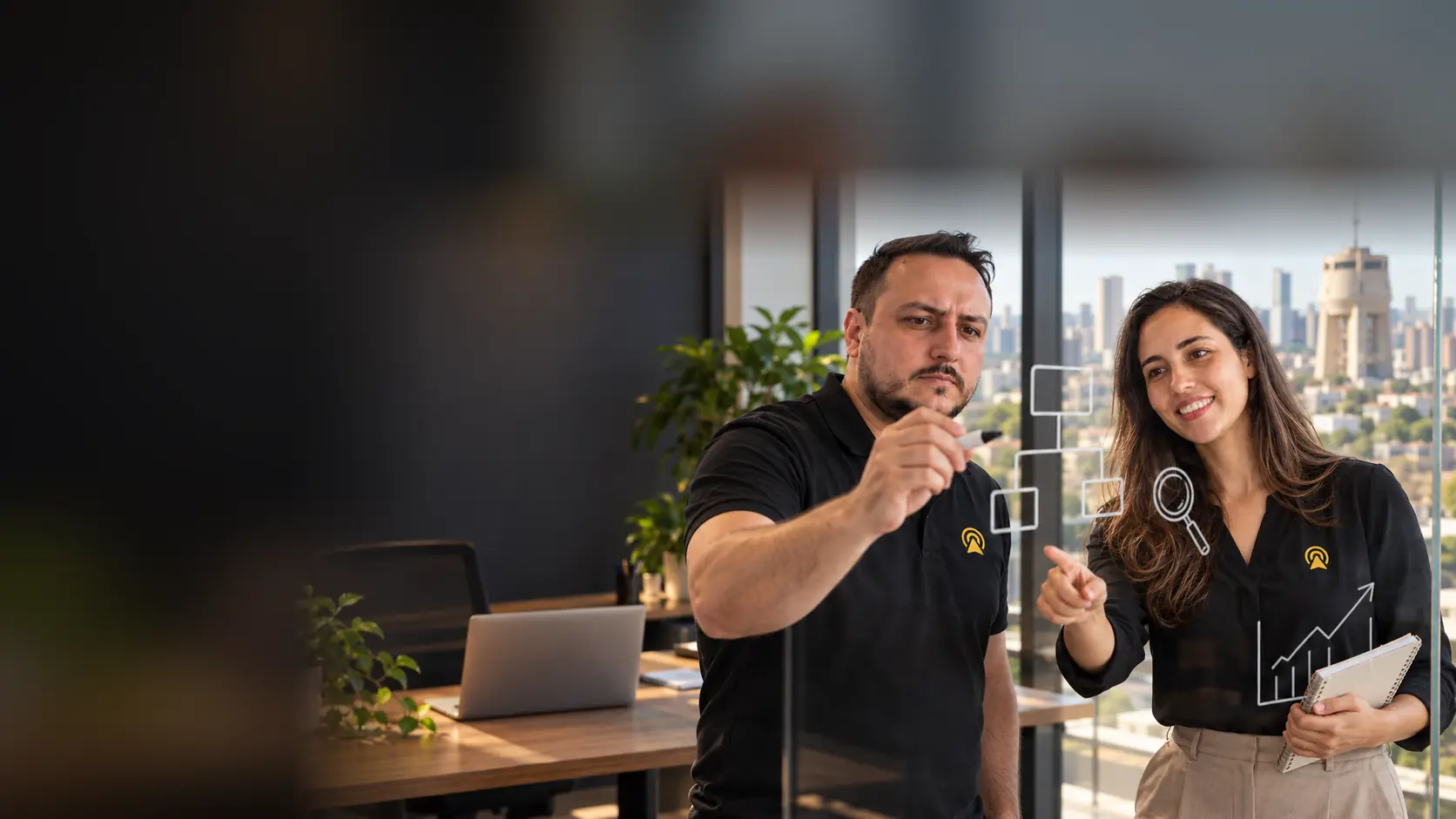 Léo e Lari analisando gráficos de desempenho em um computador e no celular