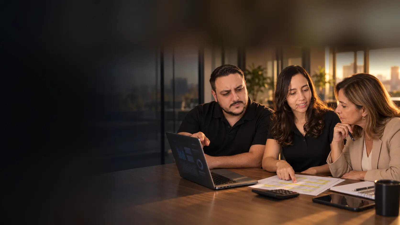 Léo e Lari conversando com uma diretora financeira sobre uma fatura destacada com marca-texto, com calculadora e painel de anúncios no notebook