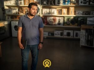 Empresário cansado em loja de eletrodomésticos pensando nos leads perdidos por demora no WhatsApp