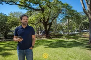 Dono de loja em Americana segurando smartphone na Praça Comendador Müller, produção de conteúdo filmmaker mobile e tráfego pago