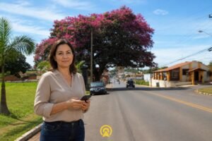 Empresária no centro de Santo Antônio de Posse segurando smartphone